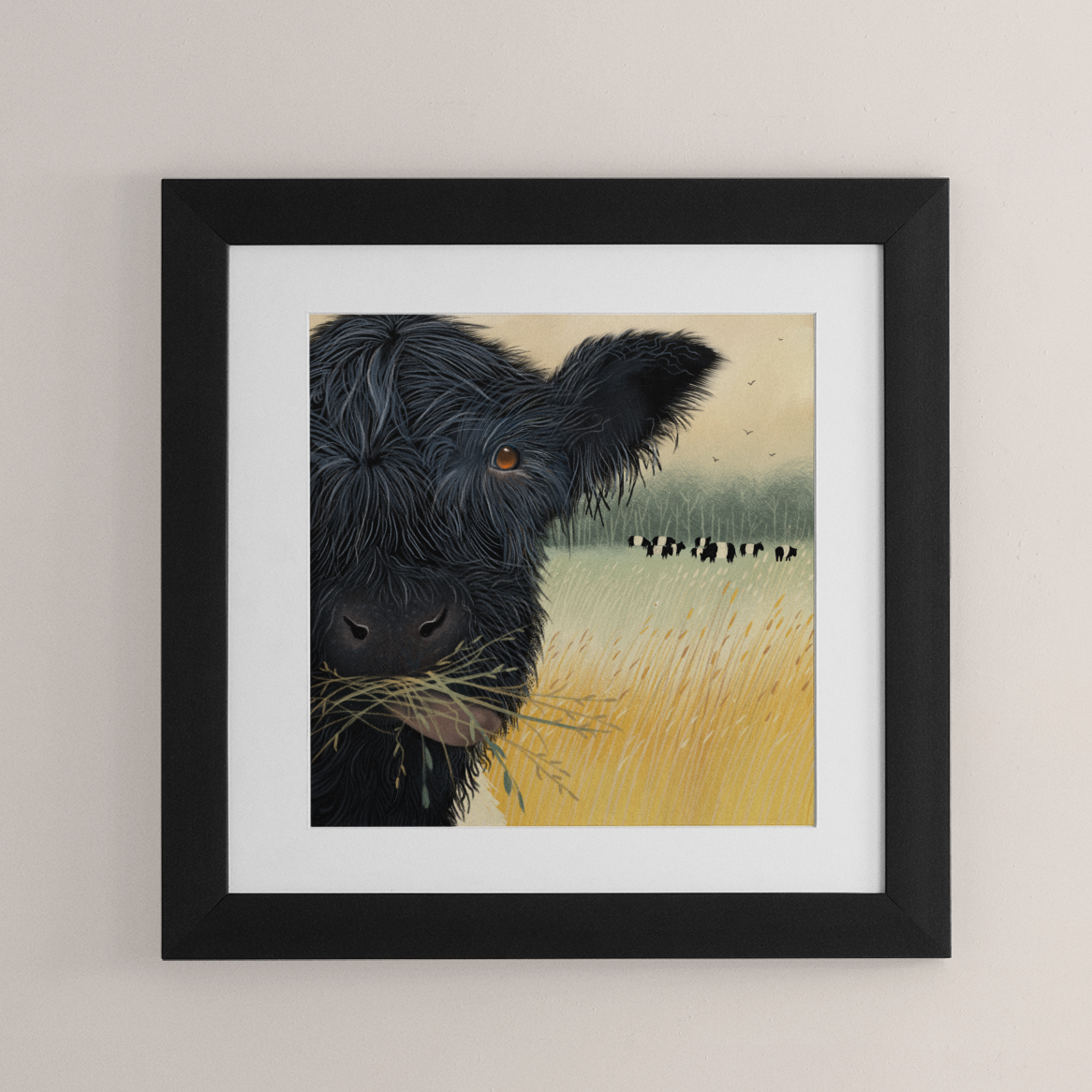 Framed artwork of a black belted galloway cow in a field on a beige wall